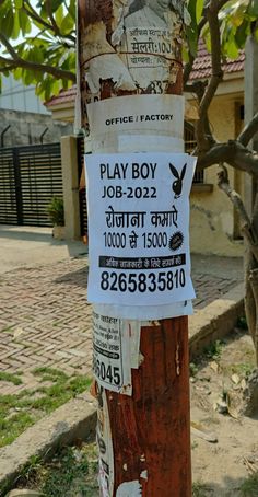 a sign on a pole that has been vandalized with stickers and writing