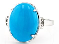 a large blue stone ring with diamonds on the sides and an oval design in the middle