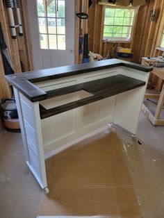 a workbench in the middle of a room with wood paneling on the walls