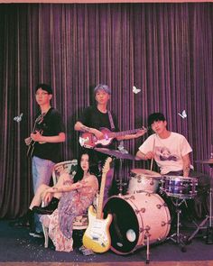 the band is posing for a photo in front of a curtain with butterflies on it