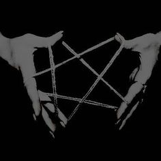 two hands holding sticks in the shape of a pentagramil, against a black background