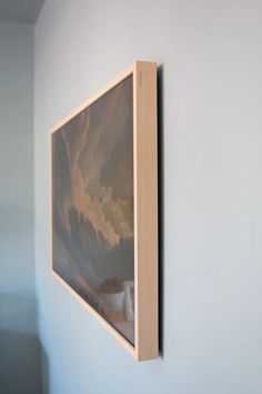 a painting hanging on the wall next to a vase