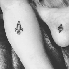 two people with tattoos on their legs and one has a rocket ship tattoo on it