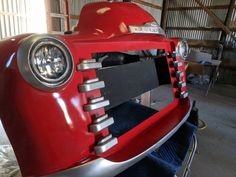 the front end of a red car in a garage