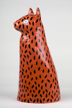 an orange and black animal statue sitting on top of a table