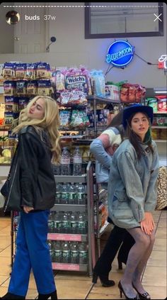 two women standing in front of a grocery store with their hands on their hipss