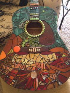 a colorful guitar is sitting on the floor