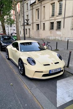 a yellow sports car is parked on the street