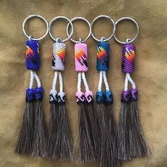 six keychains with different colors and designs on them, all hanging from metal rings