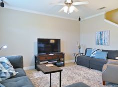 a living room filled with furniture and a flat screen tv