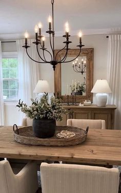 a dining room table with chairs and a tray on top of it, in front of a mirror