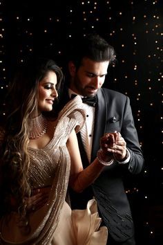 a man in a tuxedo and a woman in a gold dress dance together