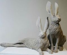 two statues of rabbits sitting next to each other