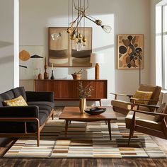 a living room filled with lots of furniture next to a wall mounted art piece on the wall