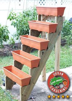 several planters are placed on the side of a wooden stair case in front of a garden