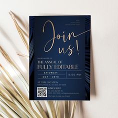 a blue and gold party card with palm fronds next to it on a white surface