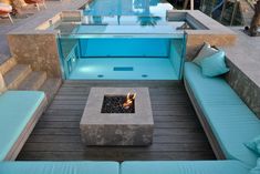 an outdoor fire pit and seating area with pool in the background