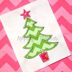 a small christmas tree on a pink and green chevron background