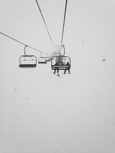 a ski lift with two people on it in the snow