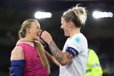 a man and woman standing next to each other on a soccer field