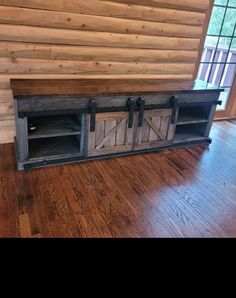 an entertainment center with sliding doors and wood floors