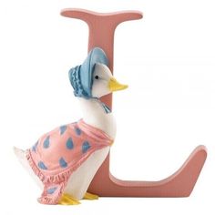 a pink and blue ducky figurine sitting next to the letter j