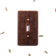 a wooden light switch plate with some gold screws on the side and one in the middle