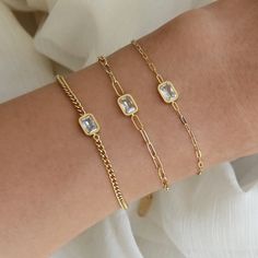 Dainty Chain Cubic Zirconia Bracelets Lengths: 6.5" + 2" extender. Lengthens up to 8.5" Measurements: 3mm or 4mm Round AAAA CZ; 6mm Emerald Cut AAAA CZ Finish: 18K over surgical steel Tarnish Resistant and Waterproof Nickel Free and Lead Free. Hypoallergenic Made in the USA Vancleef Rings, Signature Inspiration, Solitaire Bracelet, Bracelet Emerald, Bracelet Styles, Paperclip Bracelet, Curb Chain Bracelet, Simple Chain, Cubic Zirconia Bracelet