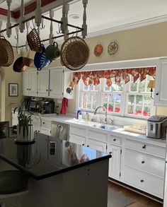 a kitchen with lots of hanging pots and pans