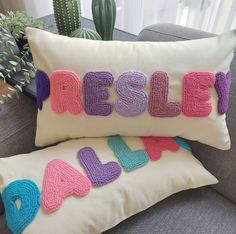 two pillows with the words resile on them sitting next to each other in front of a cactus