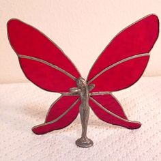 a red glass butterfly sitting on top of a table