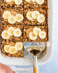 granola and banana slices on top of each other in a baking dish with a spoon