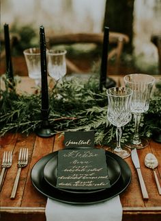 a place setting with black plates and silverware