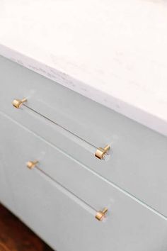 a white dresser with brass handles and drawers