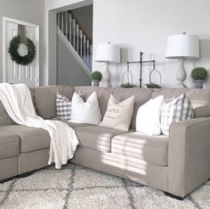 a living room filled with furniture and pillows on top of a white carpeted floor