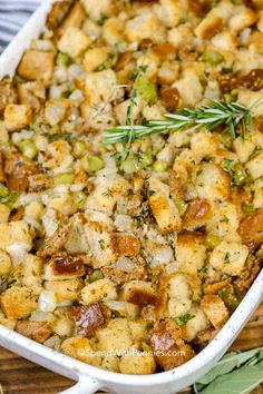 a casserole dish with stuffing and vegetables in it on a wooden table top