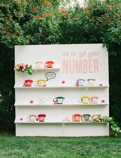 there is a sign that says we're just your number and tea cups on it