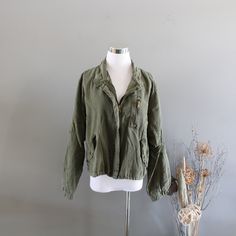 This is a beautiful light bomber jacket featuring an olive green colour soft cotton and rayon outer fabric, slouchy loose-fitting, 2 side pockets, one zipped chest pocket, full cotton lining, lightweight and timeless design. It is in excellent vintage condition.  ✂------ M e a s u r e m e n t s -------- *Measured with garment laid flat and unstretched (inch) * armpit to armpit : 21 * shoulder : 18 * sleeve : 22 * total length : 22 * Size : fit like S-M ♥ Visit my shop https://www.etsy.com/ca/shop/amilialia All the vintage goodies in my shop are carefully hand-picked by myself in CANADA. The quality of the garment will be checked thoroughly before listing. If there is any imperfection, it will be stated in the listing description. I love and take pride in all the clothes in my shop and I wo Khaki Long Sleeve Cargo Outerwear, Khaki Long Sleeve Cargo Style Outerwear, Olive Long Sleeve Cotton Utility Jacket, Long Sleeve Military Utility Jacket, Military Long Sleeve Cargo Utility Jacket, Khaki Long Sleeve Utility Top, Olive Military Style Tops For Fall, Olive Military Utility Jacket For Spring, Fall Military Green Tops