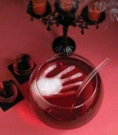 a red table topped with a glass bowl filled with liquid