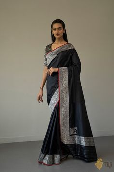 "\nEnchanting like a new moon night, this is a ravishing katan silk saree. With an intricate silver zari\u00a0border\u00a0and a magnificent koniya aanchal on a bed of\u00a0black like the night sky, this saree will take your breath away!\n\u00a0\n\n\n\n Color\u00a0- An always stunning\u00a0shade of\u00a0Black\n\n Technique\u00a0- An enduring Kadwa weave. The elaborate and laborious Kadwa (Kadhua) technique involves hand-weaving each motif separately. It takes longer on the handloom, but makes a more robust pattern, which stands out on the fabric.\n\n Fabric\u00a0- Soft as butter, pure Katan silk\n\n Speciality\u00a0- A magnificent\u00a0koniya aanchal or paisleys at its corners. The corners are particularly difficult to weave as they are a break from the running pattern, but koniyas look mag Katan Silk Saree, Black Pure, Brocade Blouses, Moon Night, Katan Silk, Designer Dresses Indian, The Night Sky, New Moon, Handloom Saree