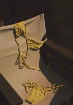 a pair of yellow string tied to a white sheet on top of a wooden bed