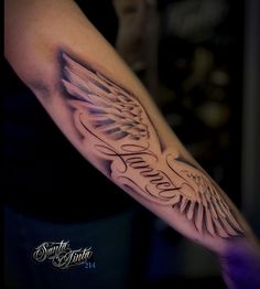 a man's arm with an angel wing tattoo on the left side of his arm