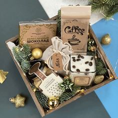 a gift box filled with coffee, cookies and other holiday treats next to christmas decorations