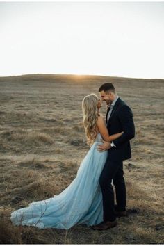 a man and woman standing next to each other in a field