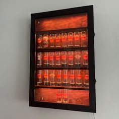 a display case with many glasses in it on the wall next to a white wall