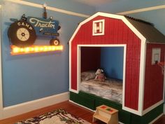 a child's bedroom with a red barn bed