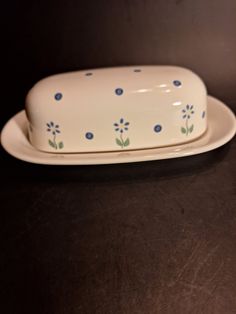 a white dish with blue flowers on it and a black table in the back ground