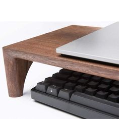 a computer keyboard sitting on top of a wooden desk