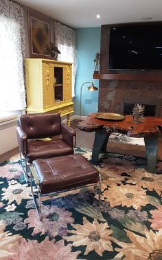 a living room filled with furniture and a flat screen tv mounted on the wall above a fireplace