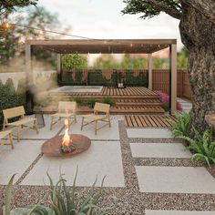 an outdoor fire pit surrounded by wooden benches and chairs with lights on them in the middle of a garden